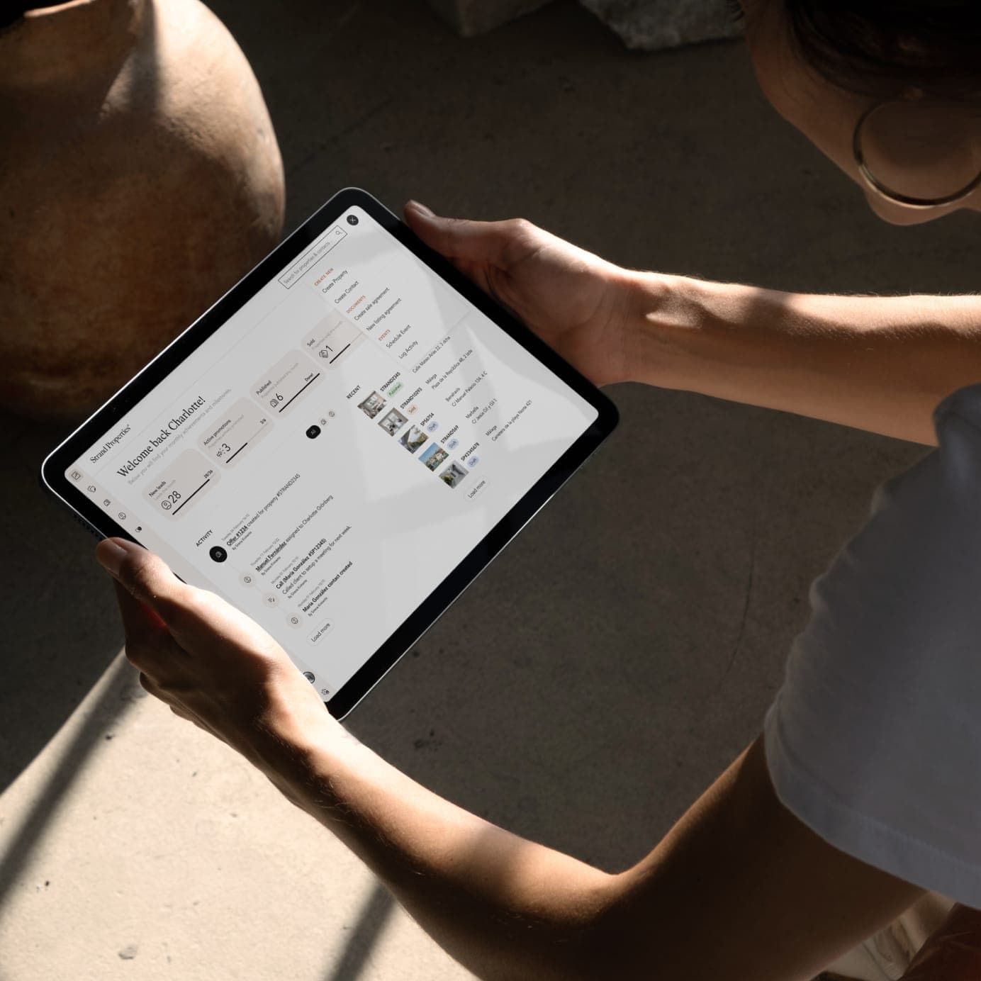 A person holding an iPad, displaying the MyStrand application in use