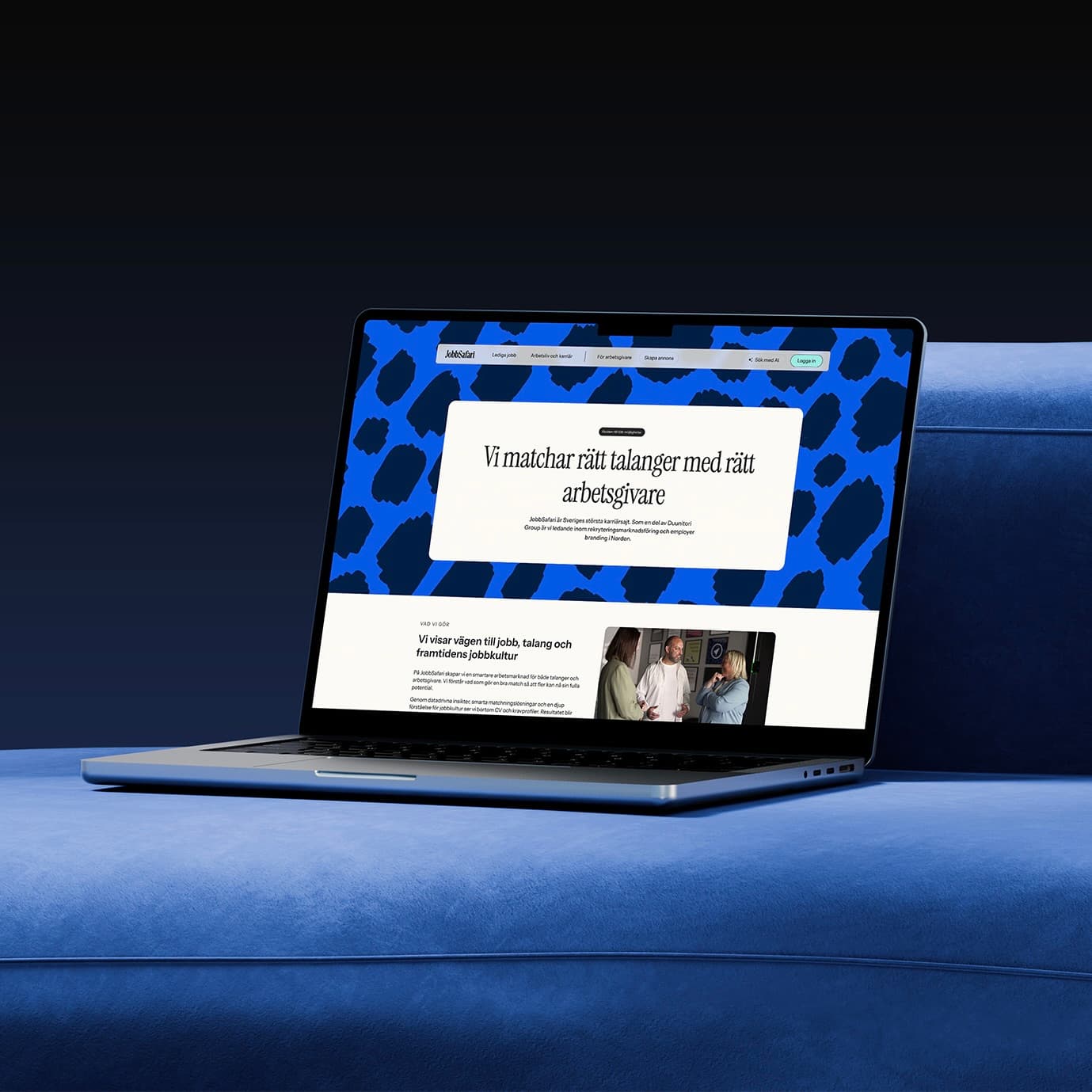 Laptop on a blue sofa showing Jobbsafari's recruitment website and blue patterned banner.